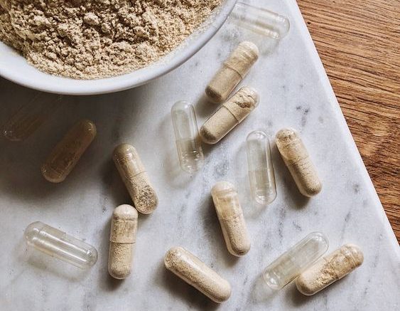 Gelule en poudre de complément alimentaire sur une table en marbre