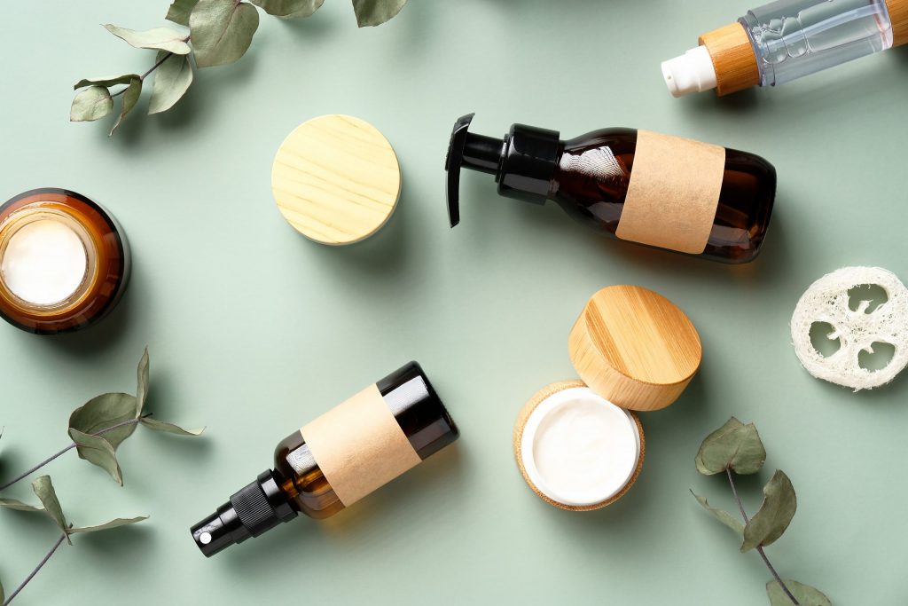 Set di cosmetici a base di erbe per SPA e foglie di eucalipto su sfondo verde. Design di prodotti di bellezza biologici e naturali, branding. Vista dall'alto.