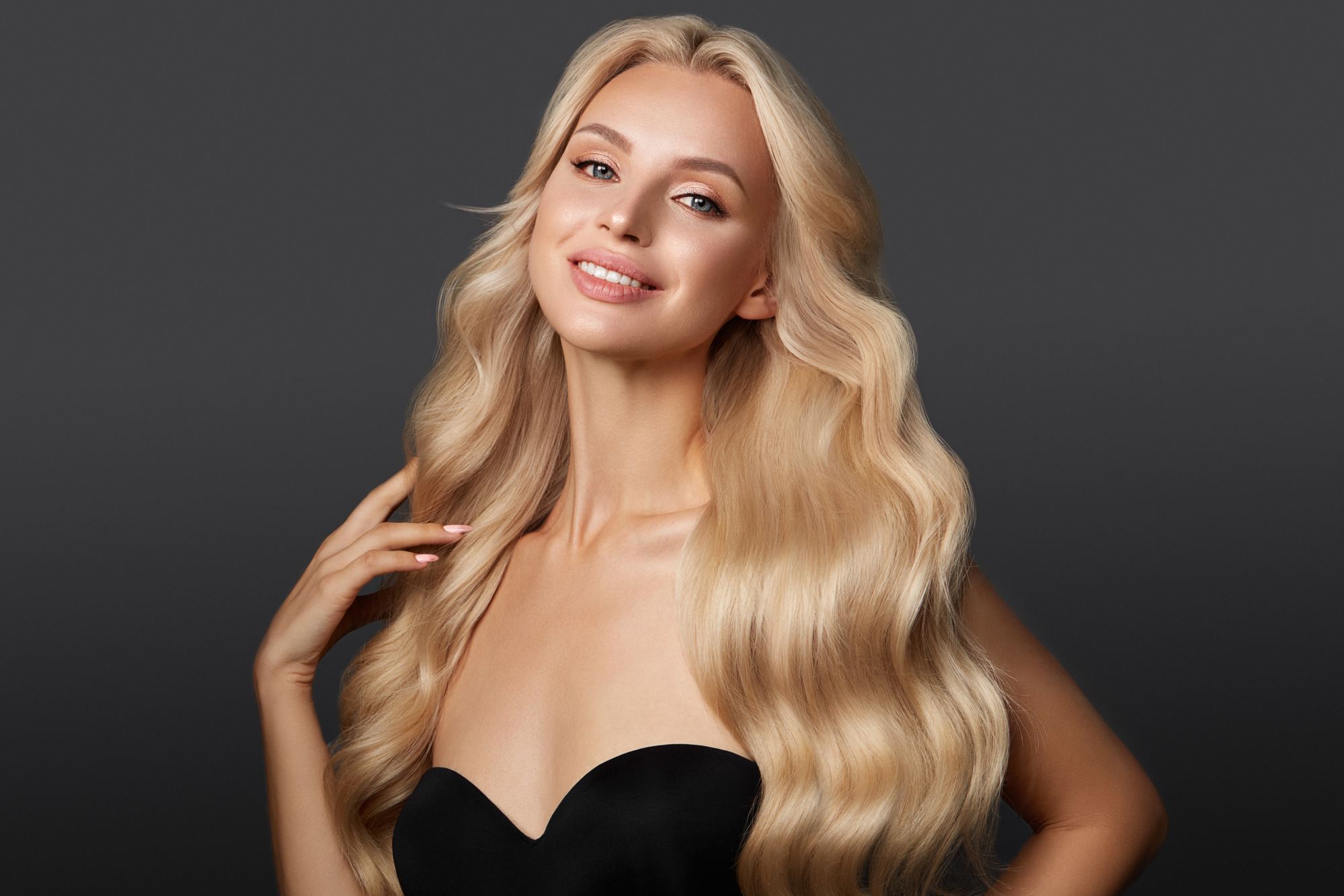 Beautiful blond girl with a perfectly curls hair, and classic make-up. Beauty face and hair.