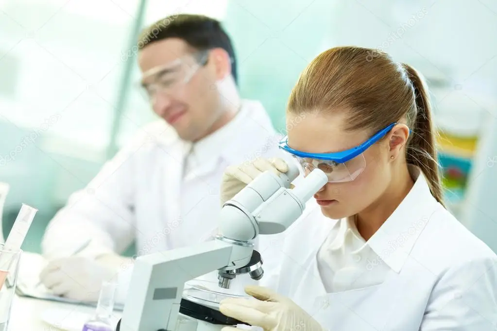 scientifique de laboratoire avec un homme et une femme regardant au microscope