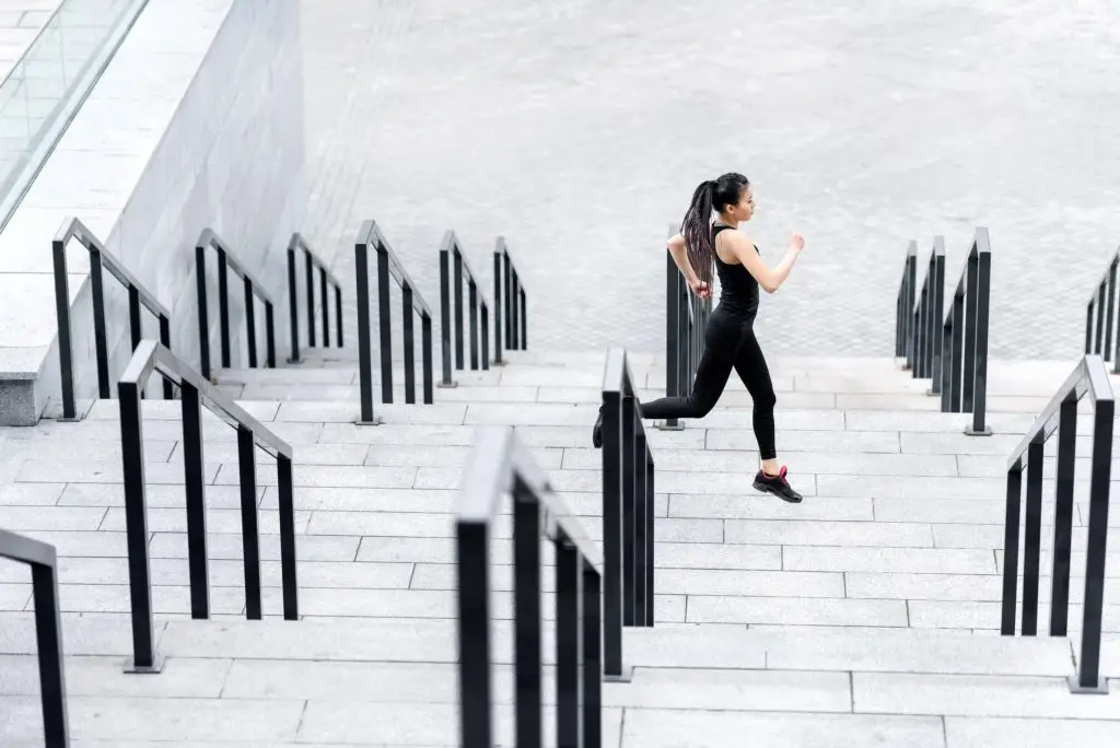 mujer corriendo en la calle con escalones