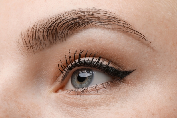 cosmetici sopracciglia e ciglia macro piano ragazza con occhi azzurri
