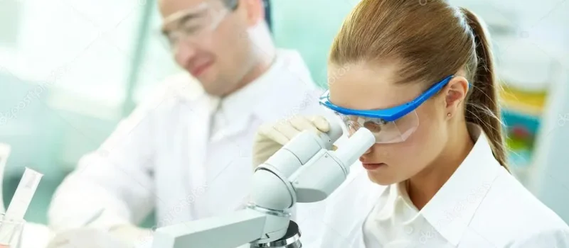 laboratorio scientifico con uomo e donna che guardano al microscopio